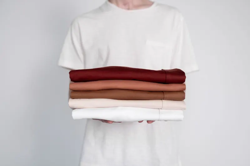 Camisetas lisas dobradas em pilha, prontas para personalização